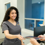 Dental assistant helps patient check in for dental appointment
