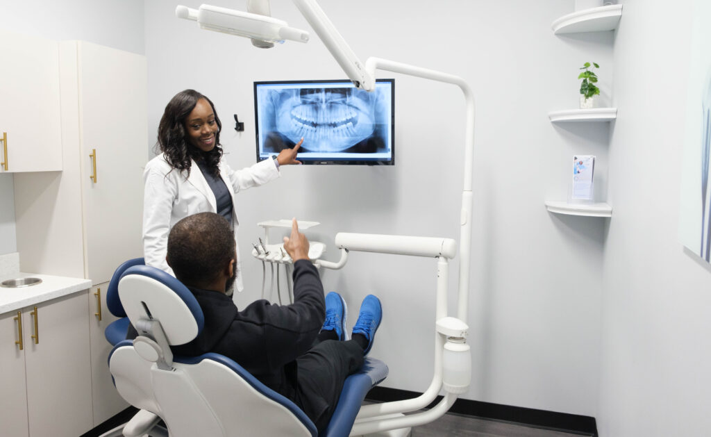 Dr. Crow showing a dental patient their dental x ray results.