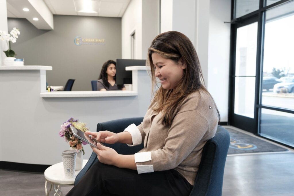 dental patient using tablet to register her visit at Crescent Dental Studio